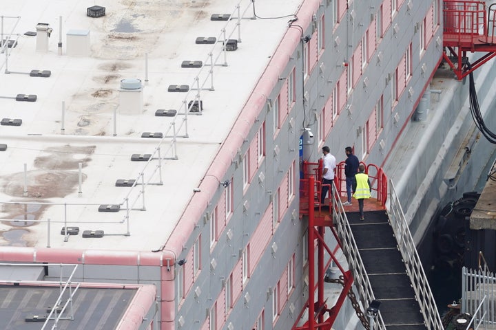 Men boarding the Bibby Stockholm accommodation barge at Portland Port in Dorset. 