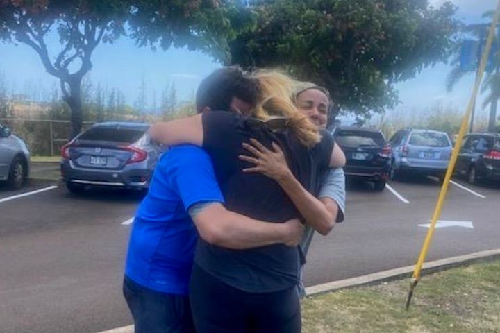 Mike Cicchino, left, and his wife Andreza, right, hugs Mike's mother Susan Ramos as they were reunited at shelter on Wednesday in Maui, Hawaii.