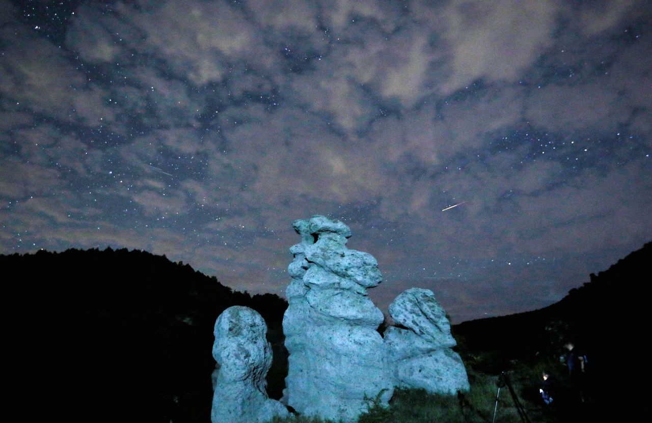 Ένας μετεωρίτης τρέχει κατά τη διάρκεια της βροχής μετεωριτών Περσείδων στον νυχτερινό ουρανό πάνω από το χωριό Kuklici, γνωστό για τις εκατοντάδες φυσικά σχηματισμένες πέτρες που μοιάζουν με ανθρώπινα όντα, κοντά στο Κράτοβο, Βόρεια Μακεδονία 13 Αυγούστου 2023
