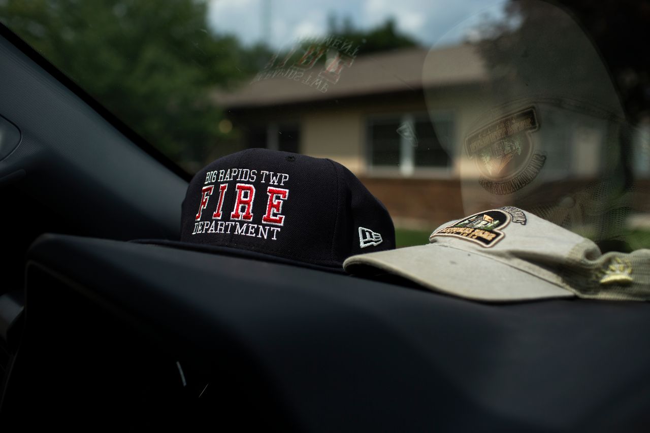 The hats on Chapman’s dashboard include one from the local fire department, where he is a volunteer captain.