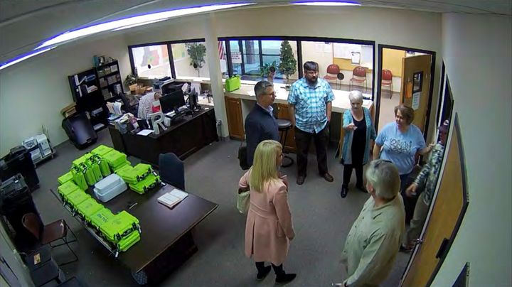 A Jan. 7, 2021, image from Coffee County, Georgia, security video appears to show Cathy Latham (center, in turquoise cardigan) introducing members of a computer forensic team to local election officials. Latham was the county Republican Party chair at the time. The computer forensics team was at the county elections office in Douglas to make copies of voting equipment in an effort that documents show was arranged by attorney Sidney Powell and others allied with Donald Trump.
