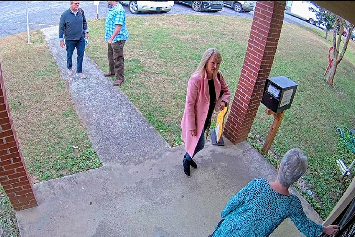 FILE - In this Jan. 7, 2021 image taken from Coffee County, Ga., security video, Cathy Latham, bottom, who was the chair of the Coffee County Republican Party at the time, greets a team of computer experts from data solutions company SullivanStrickler at the county elections office in Douglas, Ga. According to deposition testimony and documents produced in response to subpoenas, the trip to Coffee County to copy data and software from elections equipment was arranged by attorney Sidney Powell and other Trump allies. (Coffee County via AP)