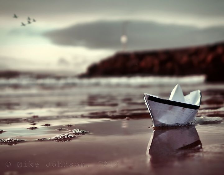 Origami boat against seascape.
