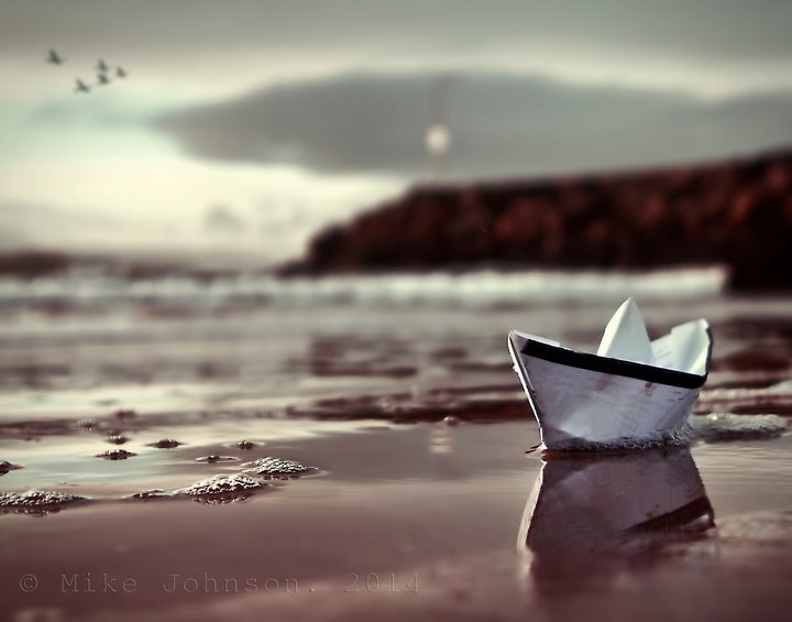 Origami boat against seascape.