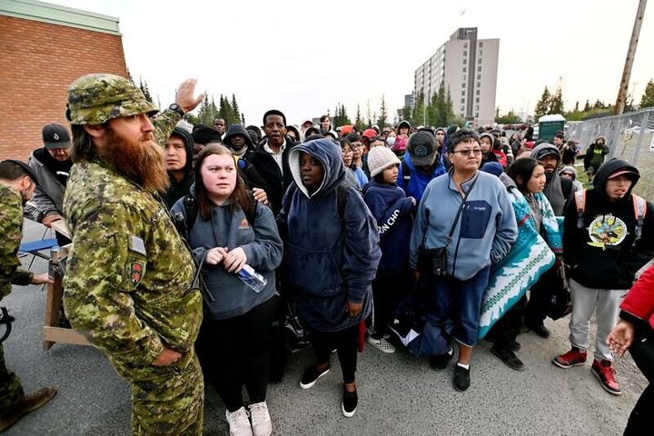 Ανθρωποι σχηματίζουν ουρές έξω από τοπικό σχολείο για να εγγραφούν στους καταλόγους εκκένωσης, στο Γέλοουνάϊφ (Καναδάς, 17/8/2023).