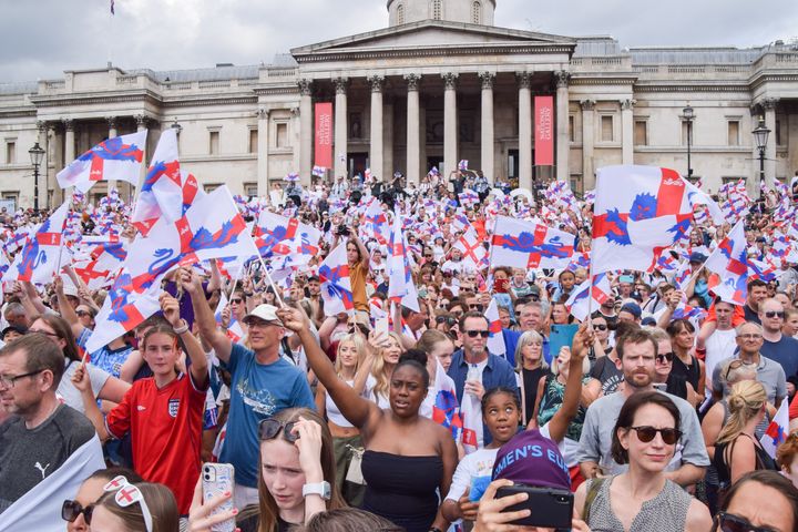 Supporters wave England flags during the Women's Euro 2022 special event in Trafalgar Square. 
