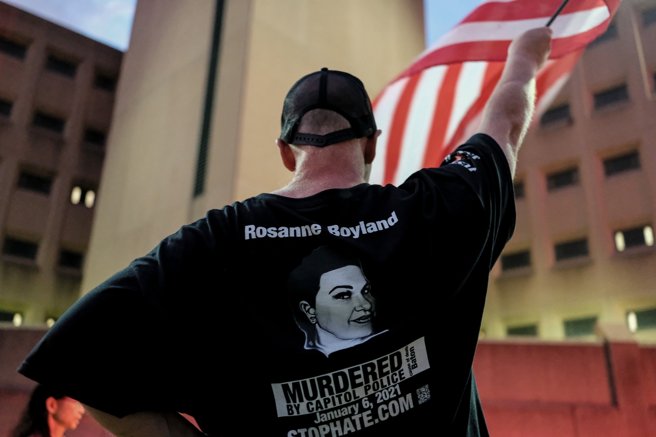 A J6 supporter holds an American flag outside of the D.C. jail.