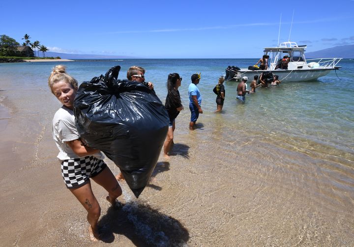 People gather to help offload a boat with supplies in Kahana, Hawaii.