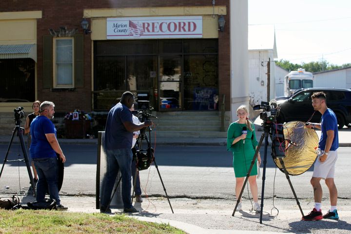 Television reporters and videographers from stations across the region prepare to do reports on the aftermath of local police raids on the Marion County Record, Wednesday, Aug. 16, 2023, in Marion, Kan. The raids on the newspaper's offices and the home of its publisher received international attention and were widely condemned by press freedom watchdog groups. (AP Photo/John Hanna)