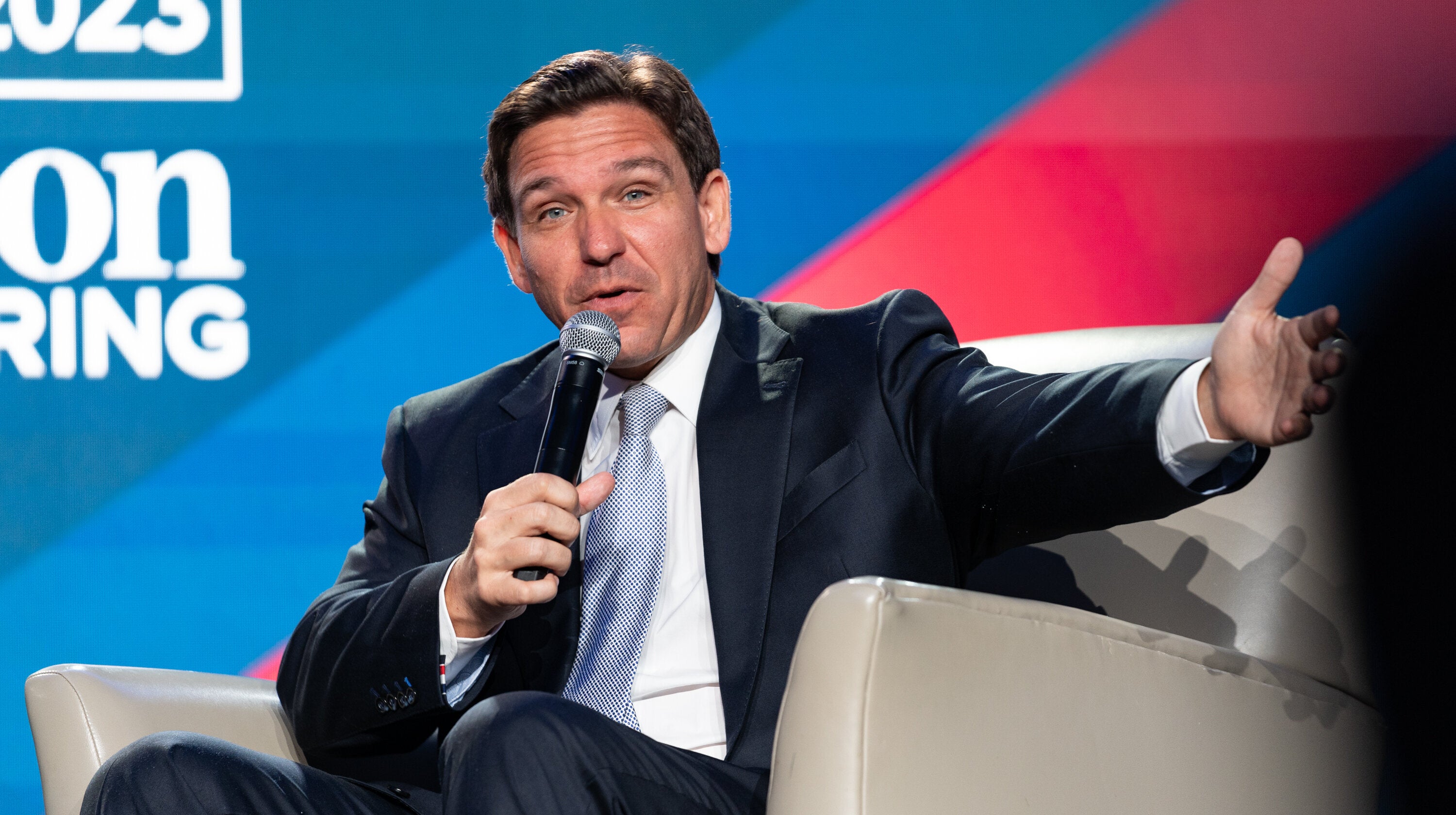 Ron DeSantis speaking to a crowd with a mic in his hand