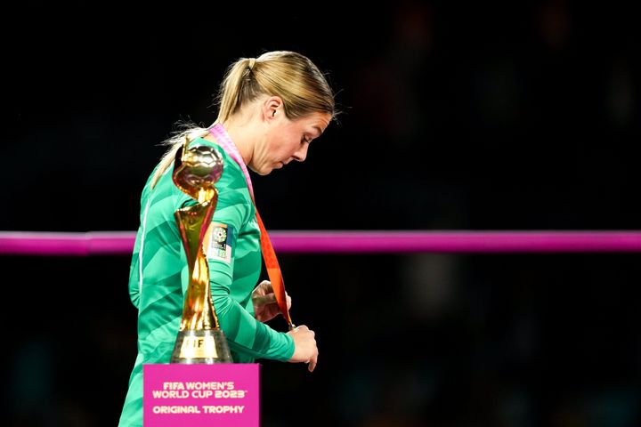 Mary Earps #1 of England walks dejected and disappointed by the World Cup trophy with her silver medal.