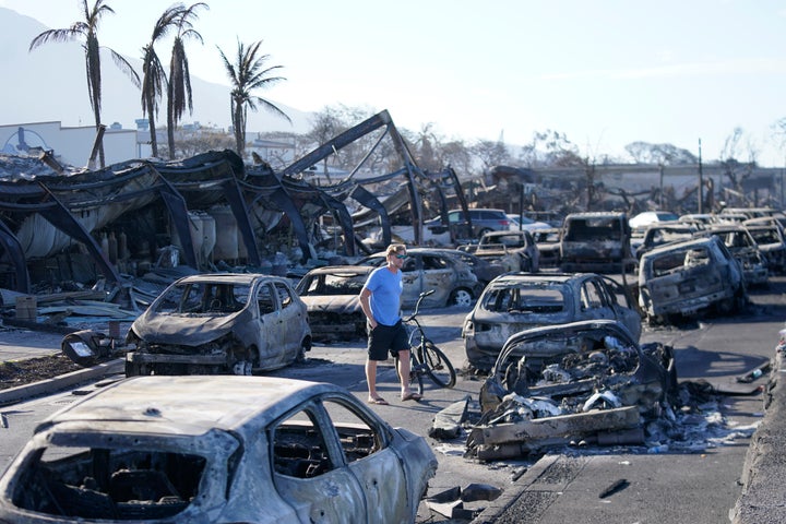 A man walks among burned-out cars in Lahaina, Hawaii, on Friday.