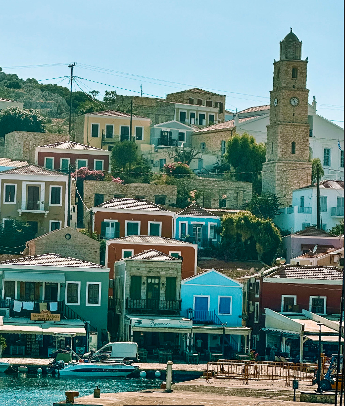 Τα πολύχρωμα σπιτάκια της Χάλκης. Στο βάθος ξεχωρίζει ο πέτρινος πύργος του ρολογιού.