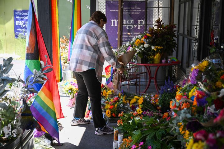A resident leaves flowers at a makeshift memorial outside the Mag.Pi clothing store in Cedar Glen, near Lake Arrowhead, California, on Aug. 21.