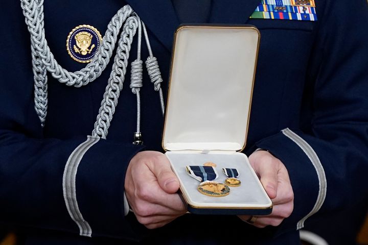 A military aide prepares to hand a Presidential Citizens Medal, the nation's second-highest civilian honor, to Biden during the White House ceremony on Jan. 6, 2023.