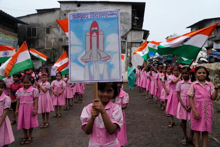 Παιδιά ανεμίζουν ινδικές σημαίες στις εγκαταστάσεις του σχολείου τους στη Βομβάη της Ινδίας για την προσεδάφιση του ινδικού σκάφους. (22/8/2023)