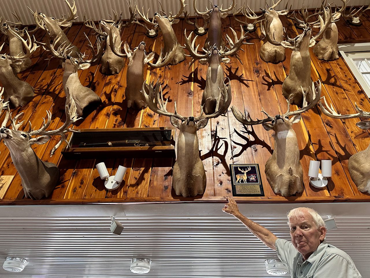 Robert Williams, owner of RW Trophy Ranch, stands before a wall of shoulder mounts made from antler sheds of deer he's bred over a three-decade career.