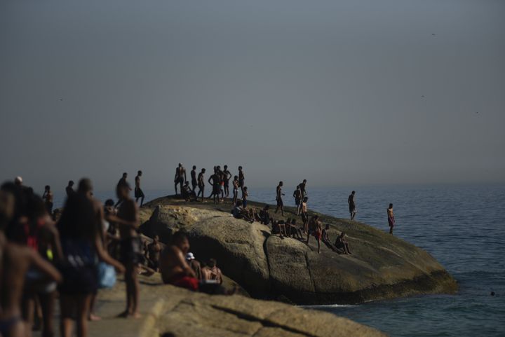 Άνθρωποι ξεχύνονται για βουτιές στην παραλία Ιπανέμα στo Ρίο ντε Τζανέιρο στη Βραζιλία, με τη θεμροκρασία να φτάνει στυς 33 βαθμούς Κελσίου εν μέσω χειμώνα (23/8/2023).