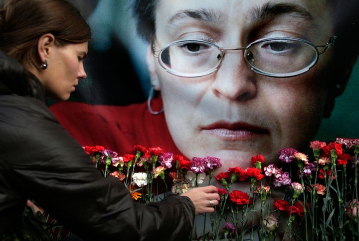 Μια γυναίκα αφήνει λουλούδια μπροστά από πορτρέτο της δημοσιογράφου Άννα Πολιτκόφσκαγια εις μνήμην της (10/2009).