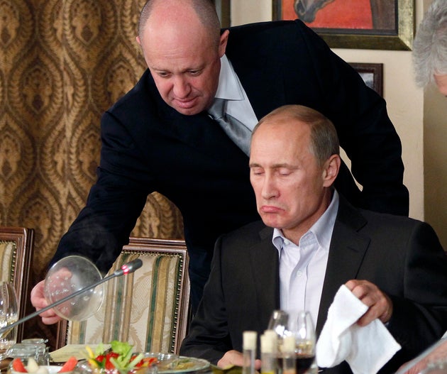Yevgeny Prigozhin, top, serves food to Russian Prime Minister Vladimir Putin at Prigozhin's restaurant outside Moscow, Russia, on Nov. 11, 2011. 