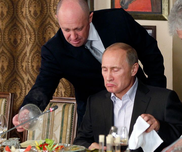 Yevgeny Prigozhin, top, serves food to Russian Prime Minister Vladimir Putin at Prigozhin's restaurant outside Moscow, Russia, on Nov. 11, 2011. 