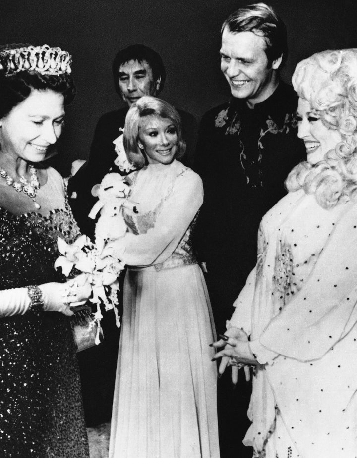 Queen Elizabeth II chats with Dolly Parton, the "Queen of Country," following a gala performance at King's Theatre in Glasgow on May 17, 1977. The performance was among the highlights of Queen Elizabeth's first day of her Scottish Jubilee tour.