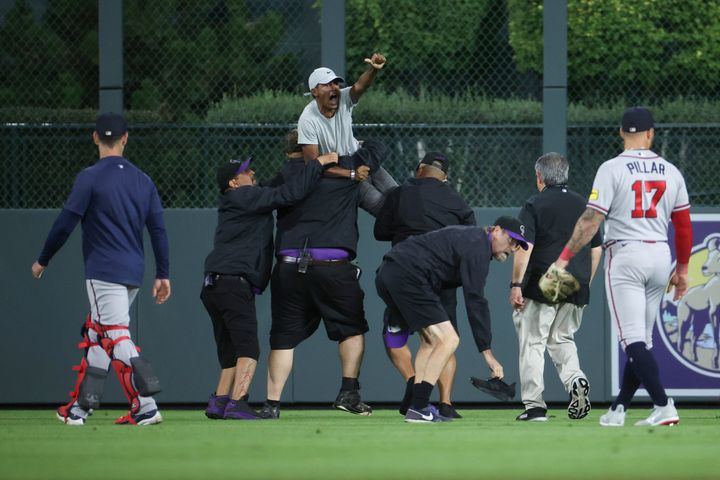 A fan yells to Ronald Acuna Jr., #13 of the Atlanta Braves after running onto the field and being apprehended by security during the game between the Colorado Rockies and the Atlanta Braves at Coors Field on Aug. 28, 2023, in Denver, Colorado.