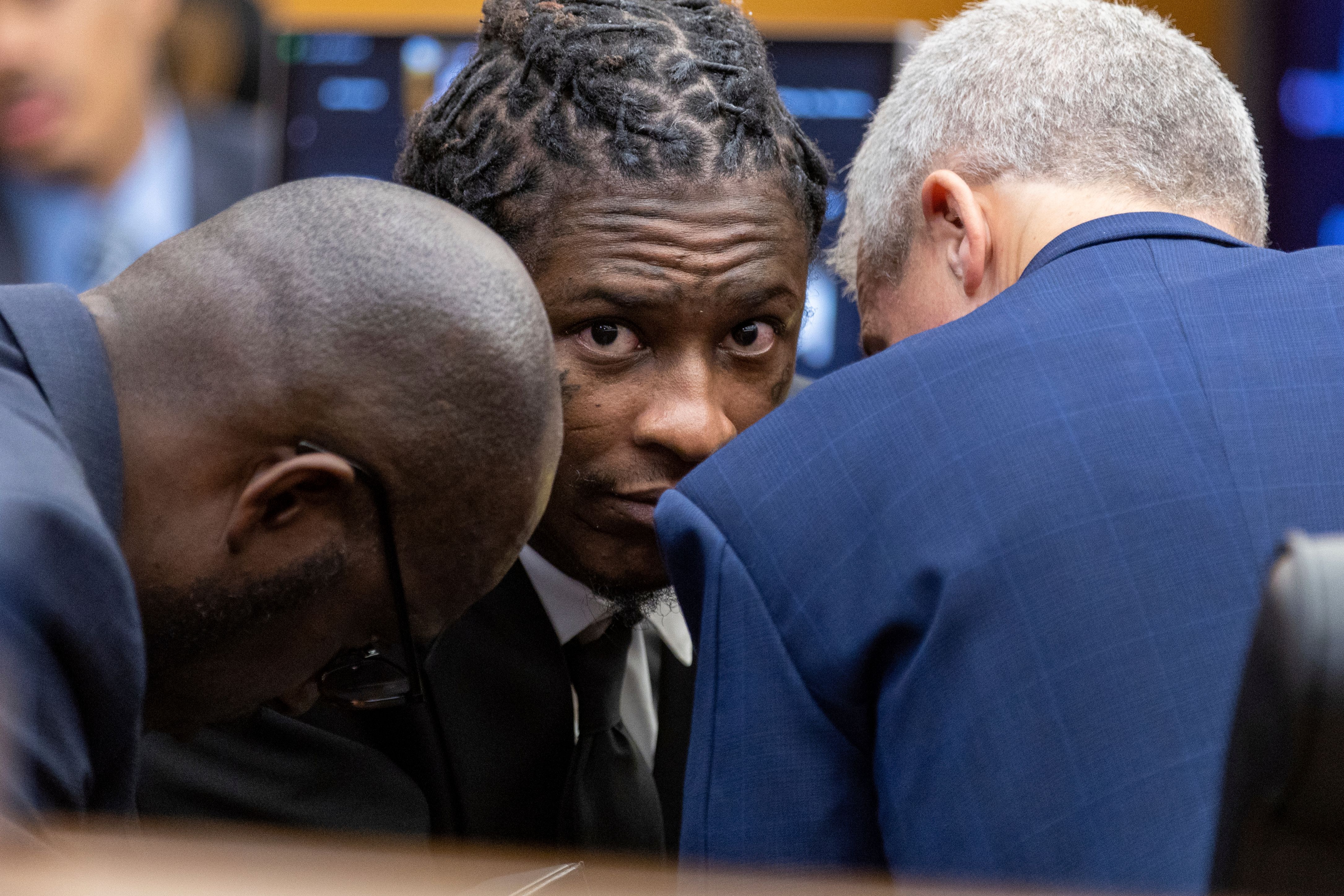 Atlanta rapper Young Thug, whose real name is Jeffery Williams, speaks with his attorneys Keith Adams, left, and Brian Steel, right, at the Fulton County courthouse in Atlanta on Thursday, Dec. 15, 2022. He was indicted in a RICO case earlier this year.