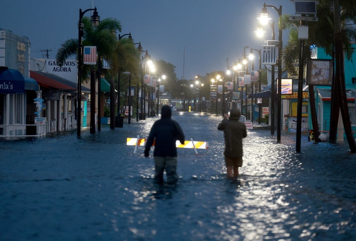 Reporters wade through flood waters in the downtown area of Tarpon Springs, Florida, on Wednesday.