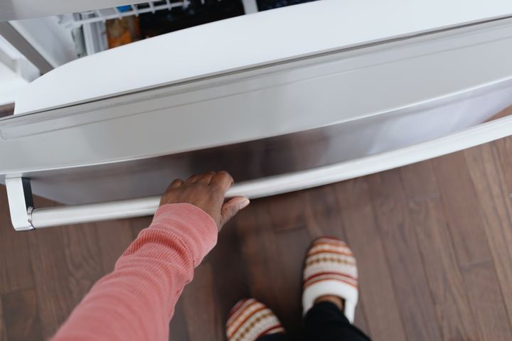 Close-up of unrecognizable black woman opening freezer door