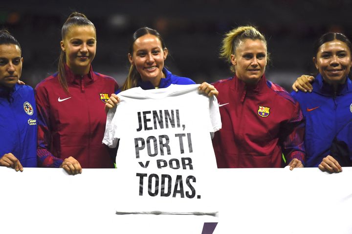 Players from Spain's Barcelona and Mexico's Club América teams hold a shirt Tuesday before a friendly match in Mexico City that translates to: "Jenni, for you and for all of us."