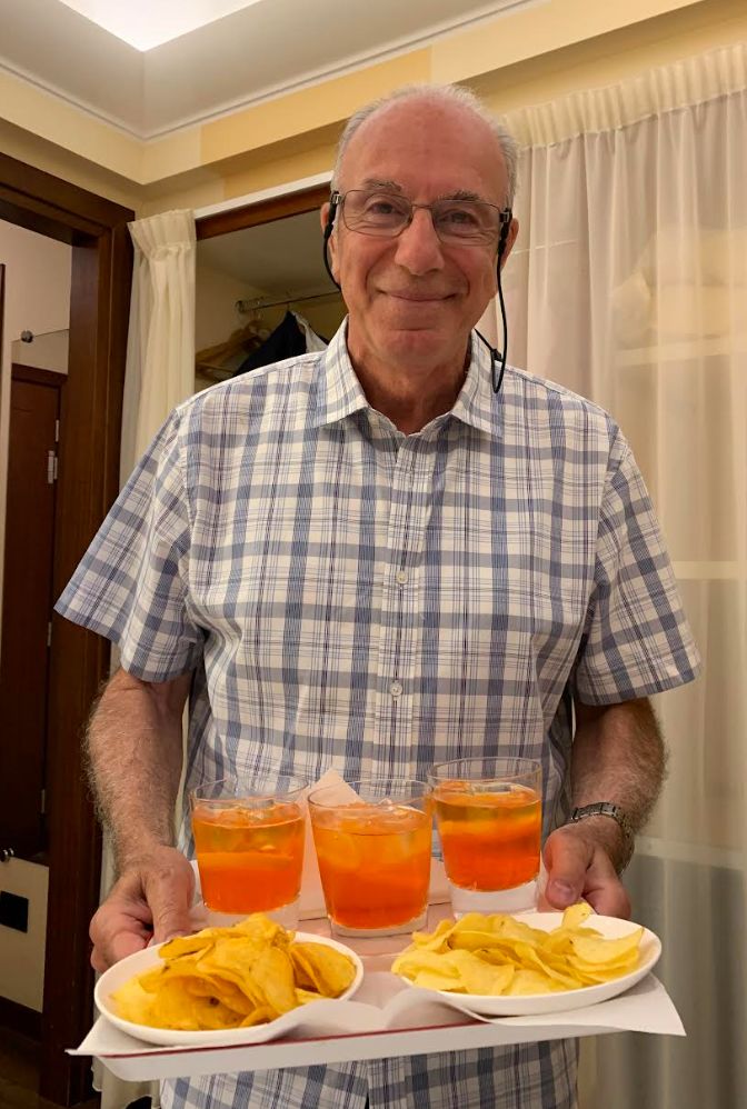The author's dad in Milan, Italy, picking up spritzes at the hotel bar in 2019. "This was his last big vacation about two years after his diagnosis," she writes.