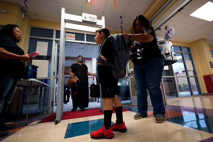 Students are checked as they pass through a metal defector as they arrive at Freedom Elementary School, on Aug. 23, 2023, in San Antonio.