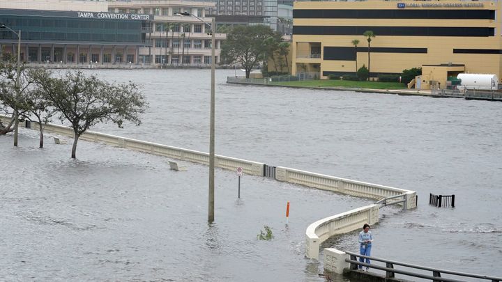 A woman surveys the flooding in Tampa, Florida, on Wednesday after Hurricane Idalia made landfall and pushed water over a sea wall.