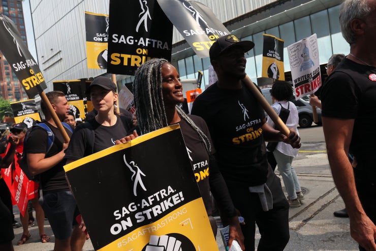 People hold signs as members of SAG-AFTRA and Writers Guild of America East walk a picket line outside of the HBO/Amazon offices during the National Union Solidarity Day on Aug. 22, 2023, in New York City. Various unions joined SAG-AFTRA and WGA East members for a National Union Solidarity Day as both unions continue their strike that has much of the entertainment industry at a standstill. Both unions are stuck in contract negotiations with the Alliance of Motion Picture and Television Producers (AMPTP), representing Hollywood studios and production companies.