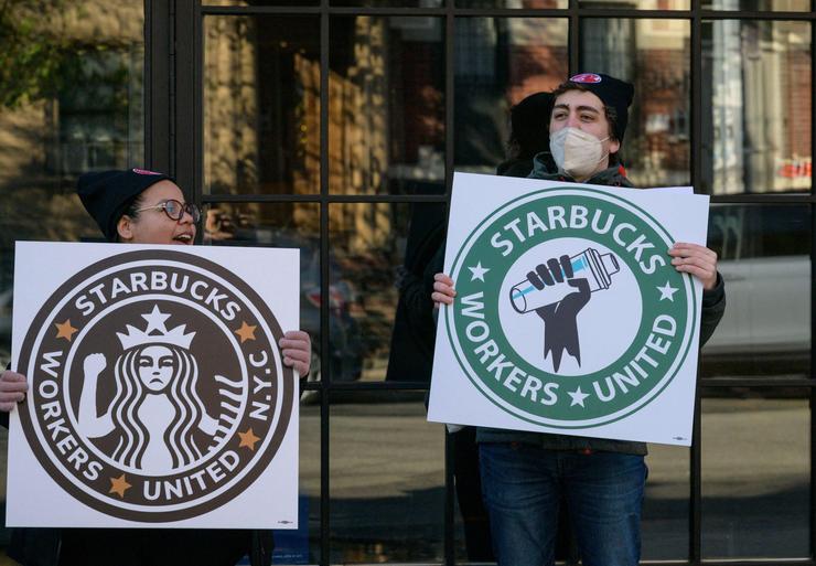 Starbucks workers strike outside a Starbucks coffee shop on Nov. 17, 2022, in the Brooklyn borough of New York City. - Starbucks workers in more than 100 US stores went on strike Thursday, according to a union, protesting the coffee giant's approach in negotiating union contracts as the company rolls out festive promotions. Dubbed the "Red Cup Rebellion," the one-day strike coincides with a popular event in which Starbucks hands out reusable cups with certain festive purchases.