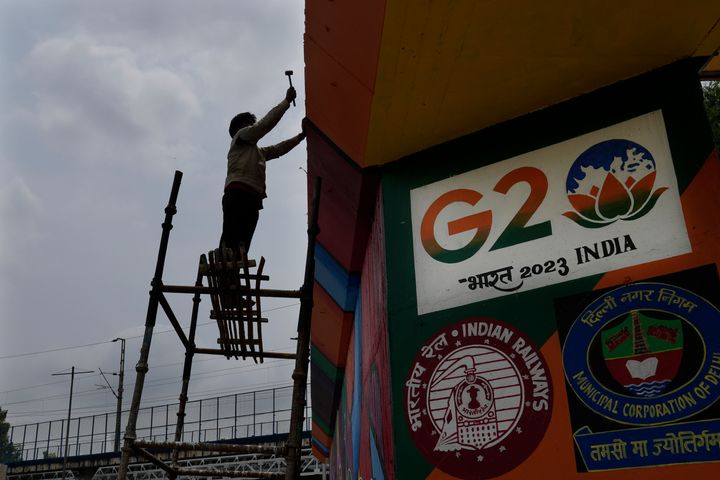 A worker paints an under-construction overhead bridge near the main venue of the G20 Summit, in New Delhi, India, on Aug. 24, 2023.