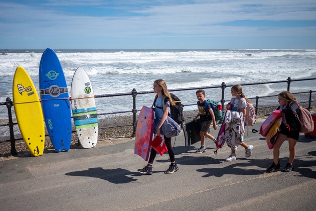 Visitors with body boards walk along the lower promenade at Saltburn beach. Beachgoers are avoiding the sea due to recent pollution alerts along the UK's North East as well as coastal regions countrywide. 