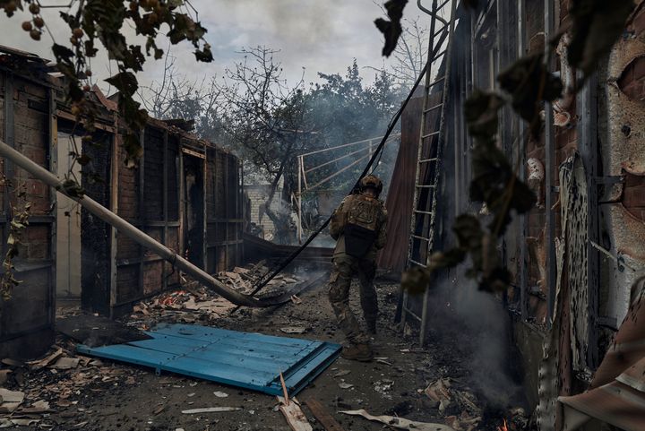 A Ukrainian soldier passes by a burning house after the Russian shelling close to the front line in Seversk, Donetsk region, Ukraine, on Friday.