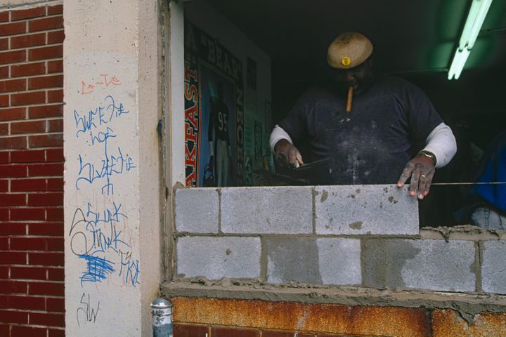 A bricklayer walls up an entrance at the Cabrini-Green housing project in Chicago amid efforts to keep out vandals and gang members.