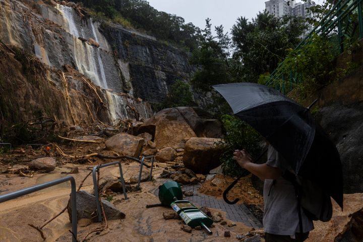 A pedestrian takes photographs of a landslide following heavy rainstorms in Hong Kong, on Sept. 8, 2023.
