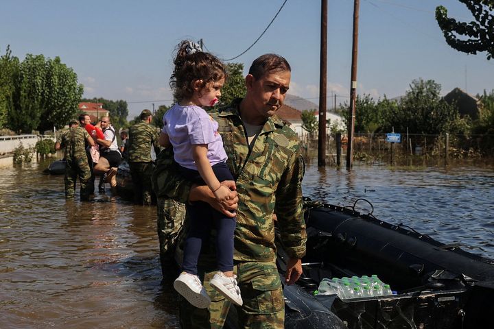 Ένας Έλληνας στρατιώτης μεταφέρει ένα κορίτσι καθώς ντόπιοι απομακρύνονται από την πλημμυρισμένη πόλη του Παλαμά, στον απόηχο της καταιγίδας Ντάνιελ στην κεντρική Ελλάδα, στον Παλαμά, Ελλάδα, 8 Σεπτεμβρίου 2023. REUTERS/Giorgos Moutafis