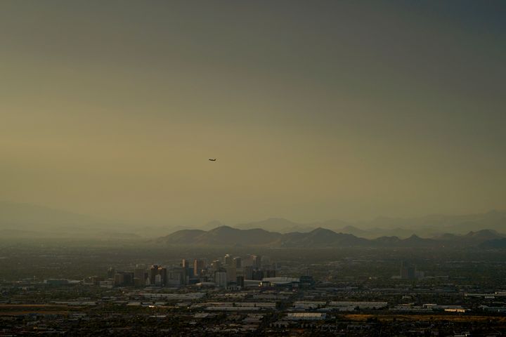 Clouds surround downtown Phoenix at sunset, Sunday, July 30, 2023. The city so far this year has seen 52 days of highs at 110 degrees or over and is expected to hit that mark again on both Saturday, Sept. 9, and Sunday. (AP Photo/Matt York)