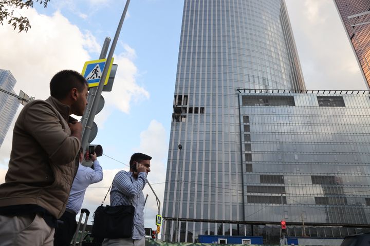 A man takes a photo of a damaged building of the Moscow-City business centre after a drone attack on August 23.