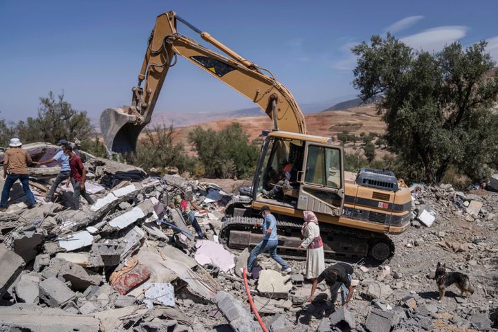 A tractor removes rubble as people search for their belongings in their home which was damaged by an earthquake, in the village of Tafeghaghte, near Marrakech, Morocco, on Sept. 11, 2023.
