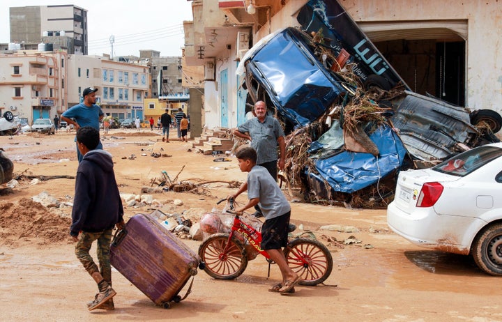 A boy pulls a suitcase past debris in a flash-flood damaged area in Derna, eastern Libya, on Monday.