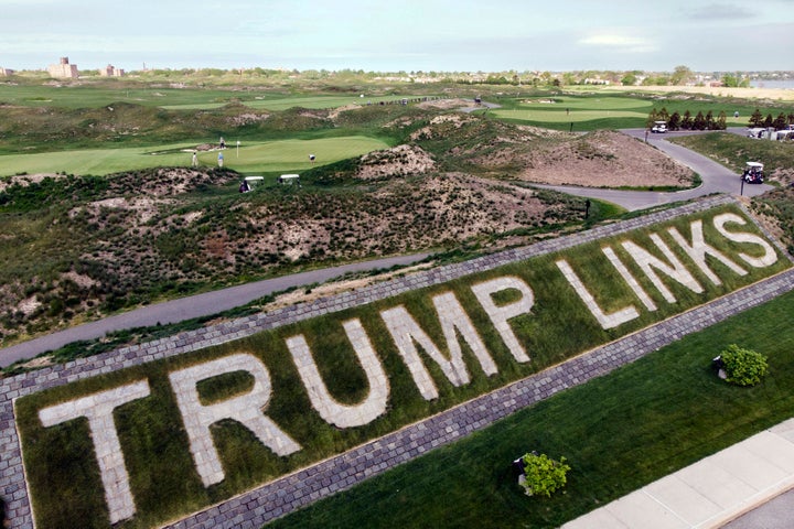 Patrons play the links as a giant branding sign is displayed with flagstones at Trump Golf Links, at Ferry Point in the Bronx borough of New York, on May 4, 2021.
