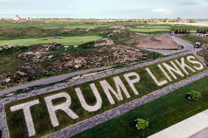 Patrons play the links as a giant branding sign is displayed with flagstones at Trump Golf Links, at Ferry Point in the Bronx borough of New York, on May 4, 2021. 