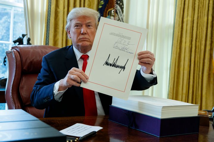President Donald Trump shows off his tax cut bill for individuals and corporations after signing it at the White House on Dec. 22, 2017.