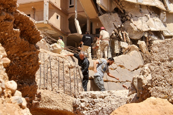 People look for survivors in Derna, Libya, Wednesday, Sept.13, 2023. Search teams are combing streets, wrecked buildings, and even the sea to look for bodies in Derna, where the collapse of two dams unleashed a massive flash flood that killed thousands of people. (AP Photo/Yousef Murad)